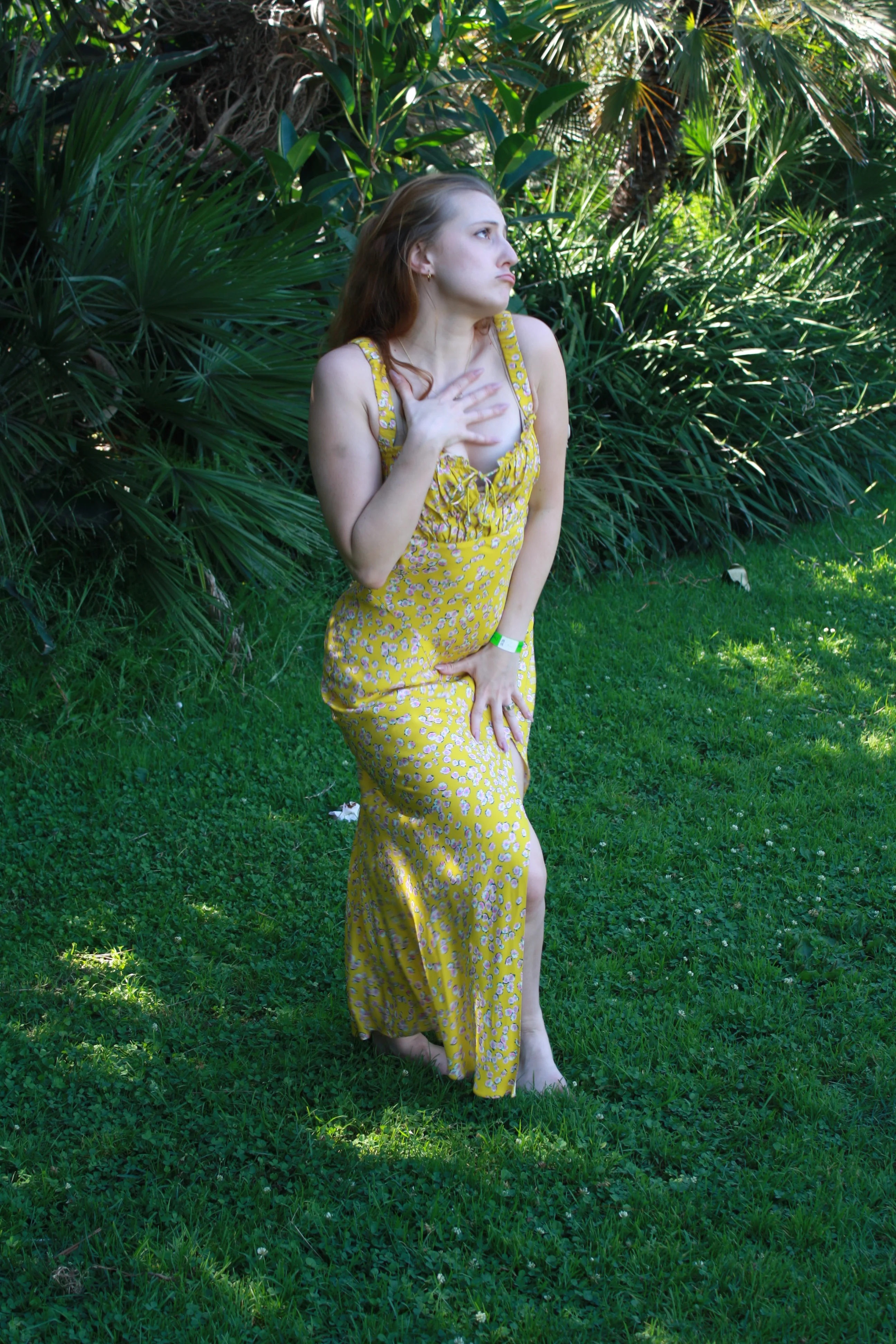 Jordie Morris looking up beside palm fronds with one hand raised at the Exposition Park Rose Garden.